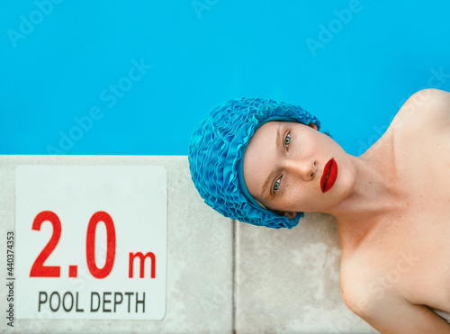 portrait of beautiful woman in pool cap laying by the swimming pool. Summer, wellness, recreation, travel concept