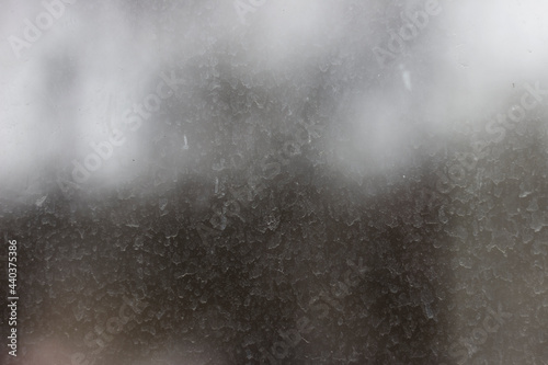 Streaks and traces of raindrops on the dirty window glass. Blurry and unfocused background. photo