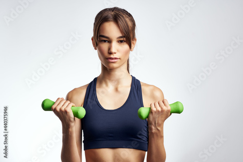 woman with green dumbbells working out in the gym motivation fitness