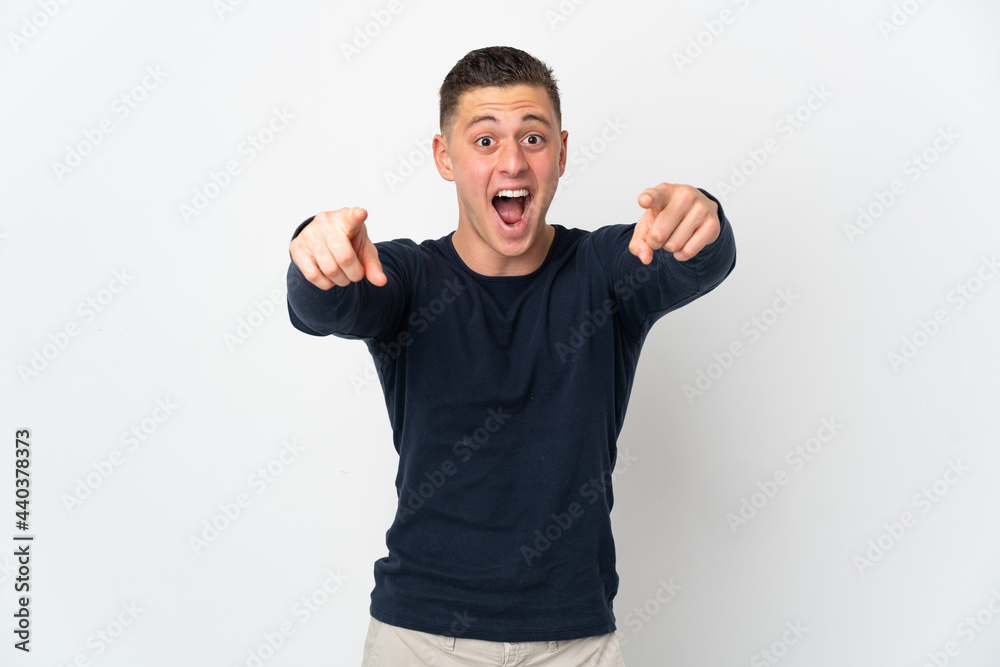 Young caucasian man isolated on white background surprised and pointing front Young caucasian man isolated on white background surprised and pointing front