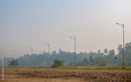 Light poles at empty clean Indian beach. photo