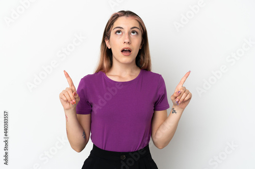 Young caucasian woman isolated on white background surprised and pointing up