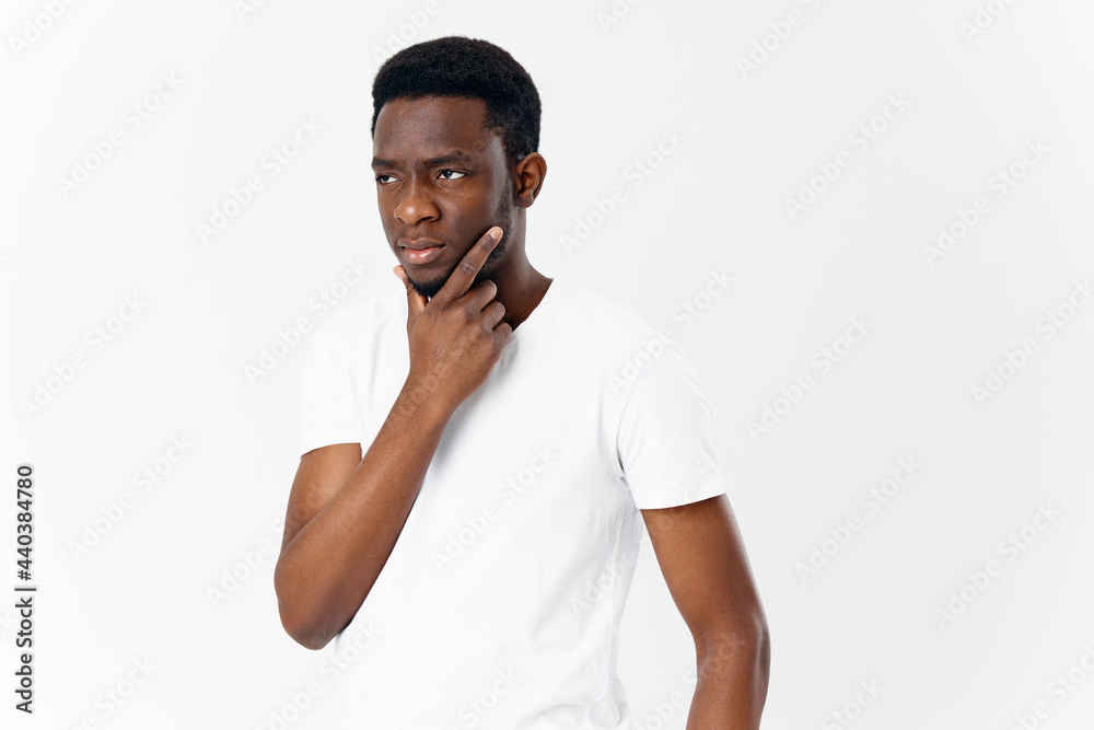 puzzled african man looking to the side touches his face with his hand puzzled african man looking to the side touches his face with his hand