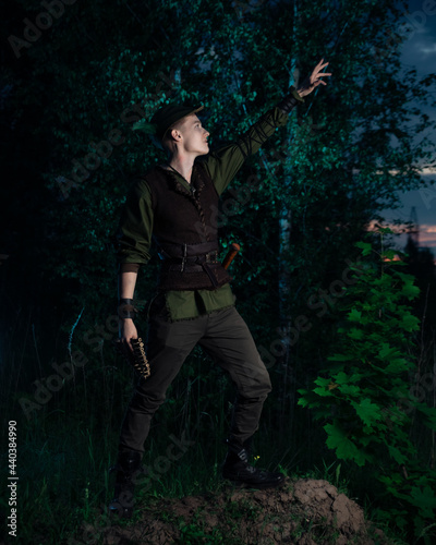 A large portrait of cosplay on Peter Pan against the backdrop of the woods at night