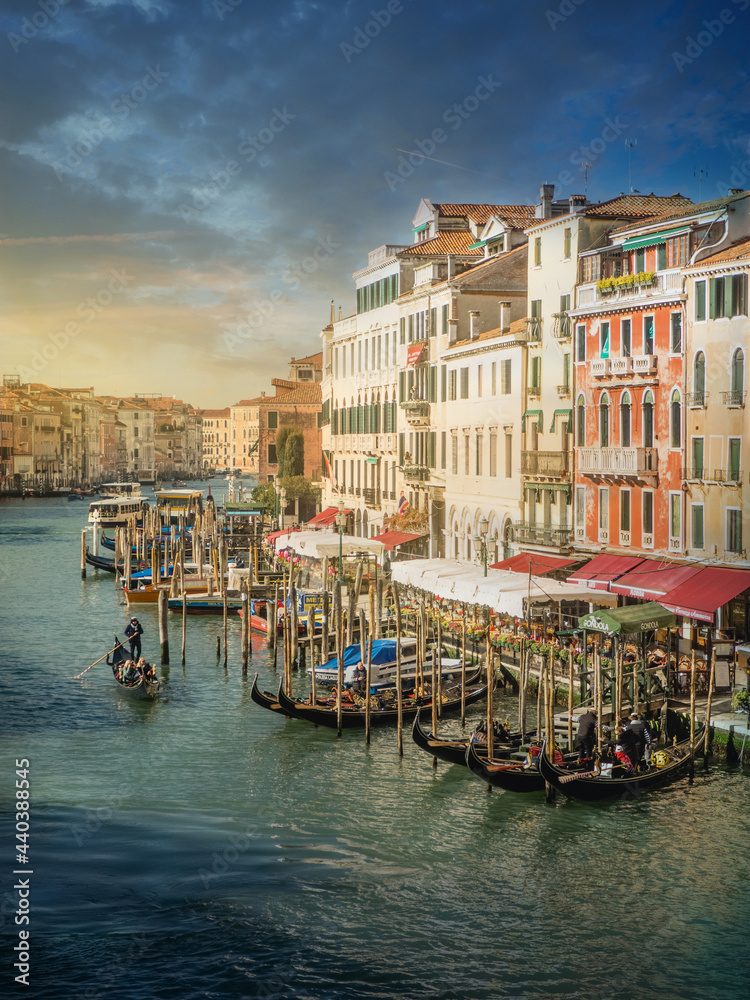 Beautiful sunrise in Venice, views of one of its famous canals crisscrossed by gondolas.