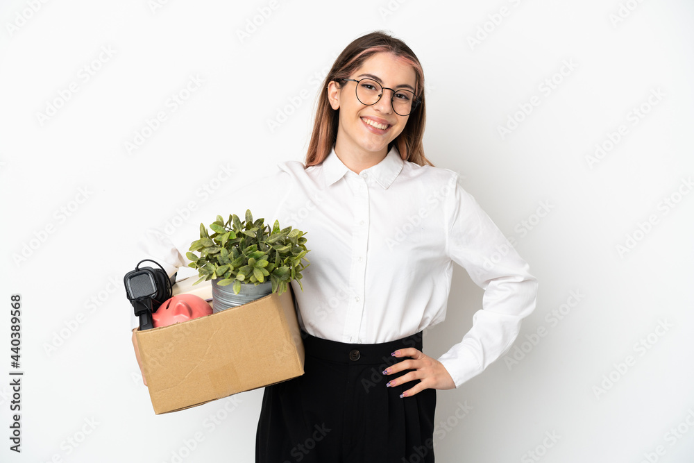 Young caucasian woman moving in new home among boxes isolated on white background posing with arms at hip and smiling Young caucasian woman moving in new home among boxes isolated on white background posing with arms at hip and smiling