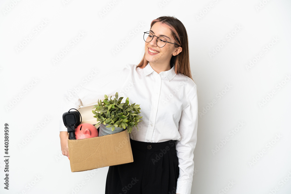 Young caucasian woman moving in new home among boxes isolated on white background looking to the side and smiling Young caucasian woman moving in new home among boxes isolated on white background looking to the side and smiling