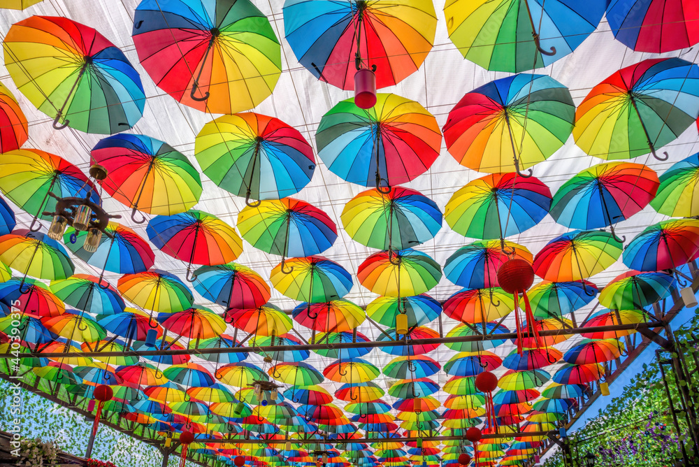 Naklejka premium Colorful umbrellas on the ceiling of a summer cafe