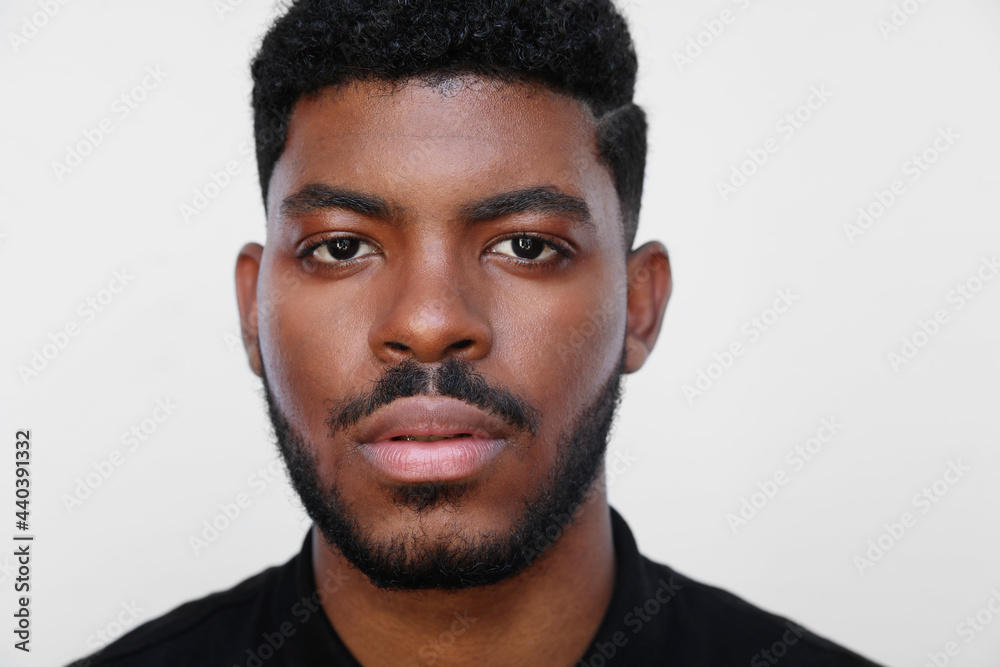 Obraz premium Focused millennial African American young serious black man looks at the camera.