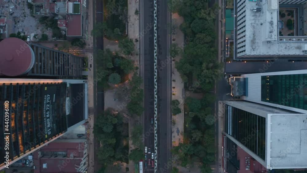 Aerial birds eye overhead top down view of wide straight street leading between tall buildings. Camera zooming out. Mexico city, Mexico. Aerial birds eye overhead top down view of wide straight street leading between tall buildings. Camera zooming out. Mexico city, Mexico.