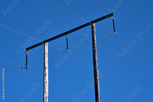 Beautiful bright view of overhead electrical power lines on old wooden pillar captured against perfectly clear blue sky, Ballycorus, Co. Dublin, Ireland. Three voltage wires. High resolution