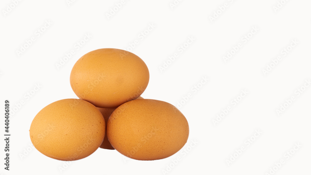 Three fresh chicken eggs on a white background with specific focus. Three fresh chicken eggs on a white background with specific focus.