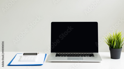 laptop computer and notebook on desk in office