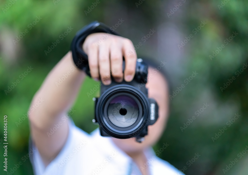 Asian man holds the Medium Format Camera in his hand and focus to shoot in front of him. Asian man holds the Medium Format Camera in his hand and focus to shoot in front of him.