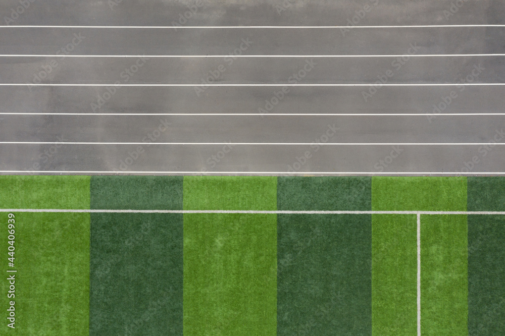 Partial top view of sports field grass and track