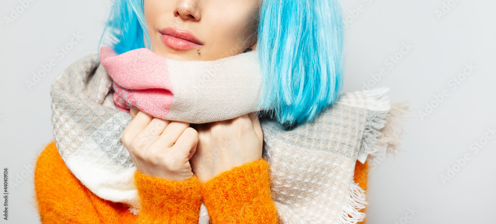 Half face portrait of beautiful girl with blue hair wearing scarf on white background. Half face portrait of beautiful girl with blue hair wearing scarf on white background.