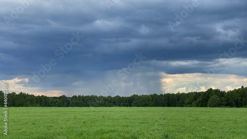 Summer thunderstorm. Stormy dramatic sky and green field