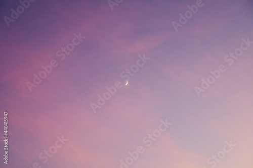 The waxing moon in a pink sky after sunset