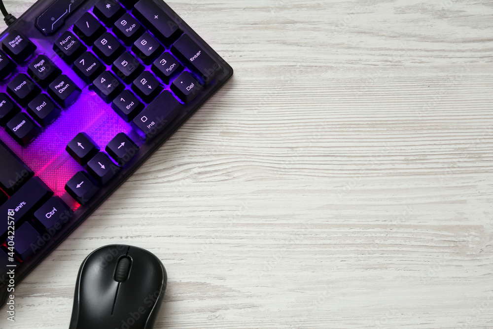 Modern RGB keyboard and mouse on white wooden table, flat lay. Space for text Modern RGB keyboard and mouse on white wooden table, flat lay. Space for text
