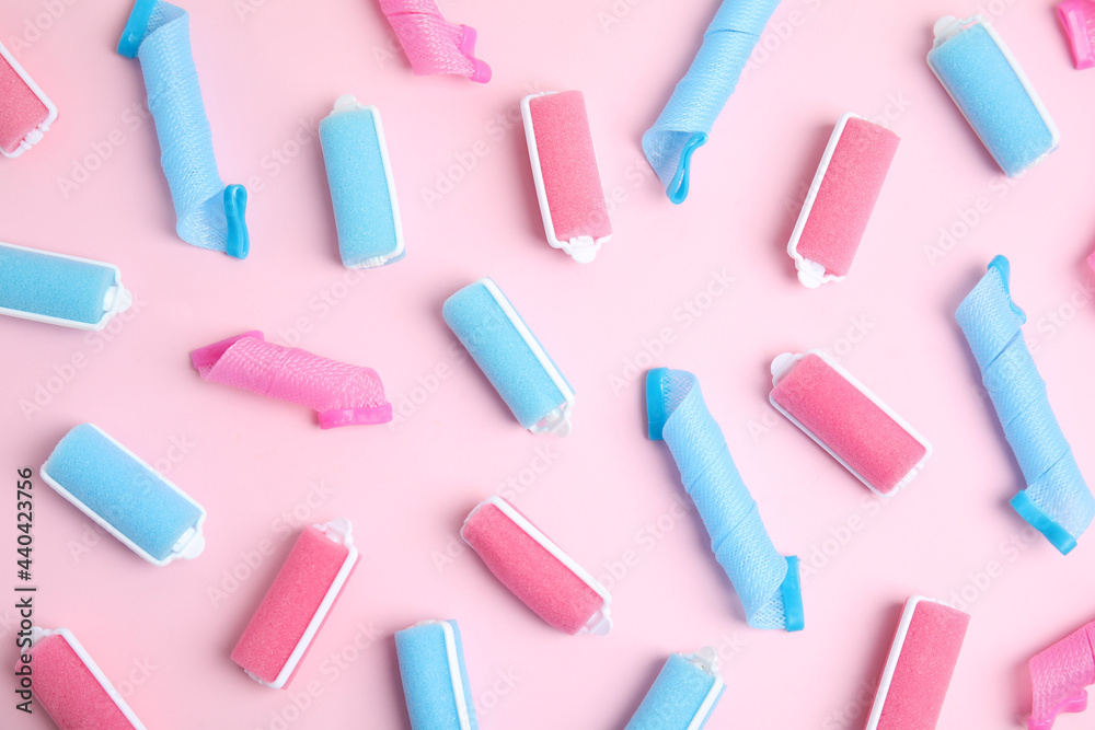 Different hair curlers on pink background, flat lay. Styling tool Different hair curlers on pink background, flat lay. Styling tool