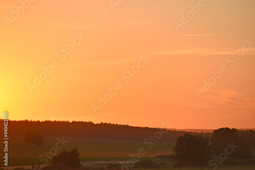 Rural field on the background of the setting sun © Lushchikov Valeriy