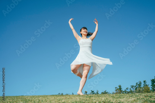空と白いワンピースの踊る女性（ピルエット） 