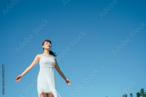 空と白いワンピースの踊る女性（深呼吸） 