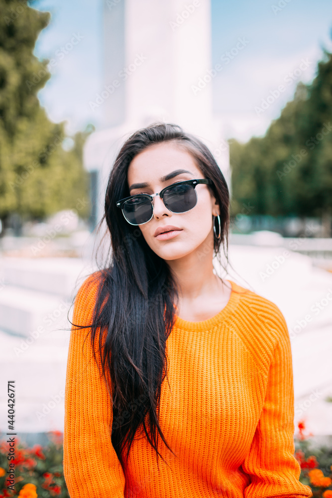 Glamour portrait of a young and beautiful woman sitting in the park. Autumn season Glamour portrait of a young and beautiful woman sitting in the park. Autumn season