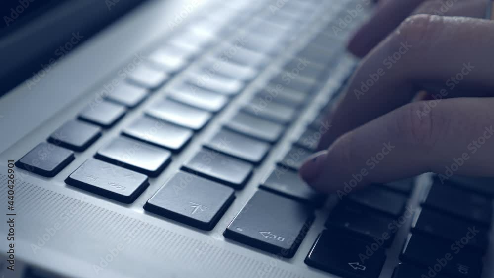 Woman typing on laptop keybord. Closeup on hands. Blue tone Woman typing on laptop keybord. Closeup on hands. Blue tone