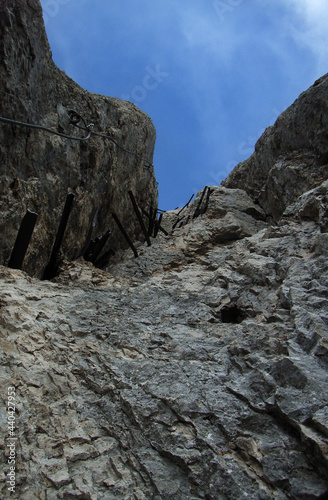 Tritteisen und Drahtseilsicherung auf einem Klettersteig in einer Felswand