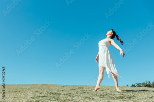 空と白いワンピースの踊る女性（深呼吸・全身） 