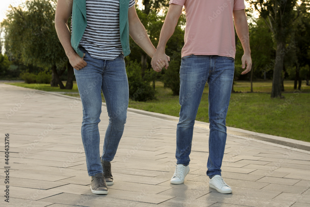 Gay couple walking outdoors on sunny day, closeup Gay couple walking outdoors on sunny day, closeup
