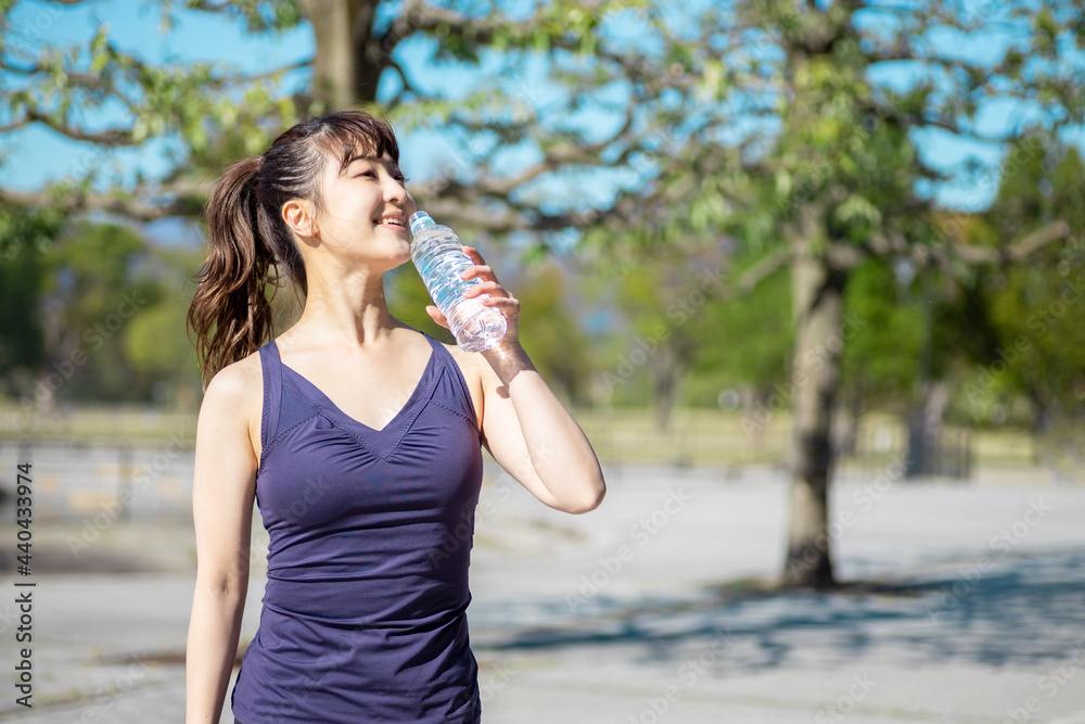 公園でトレーニングする女性(水を飲む)
公園でトレーニングする女性(水を飲む)