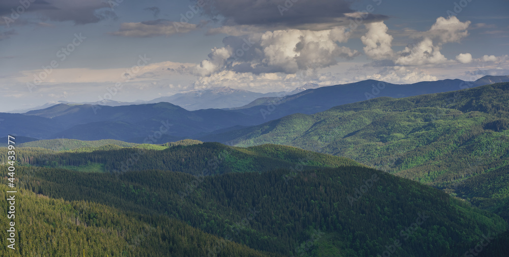 Clouds over the mountains. Sunny day in the mountains. Ukrainian Carpathian mountains.
