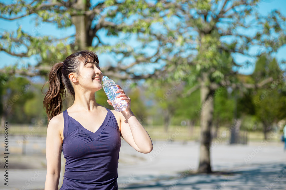 公園でトレーニングする女性(水を飲む)
公園でトレーニングする女性(水を飲む)
