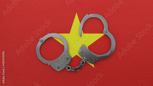 A half opened steel handcuff in center on top of the national flag of Vietnam - HandcuffStockPhoto [STEEL_