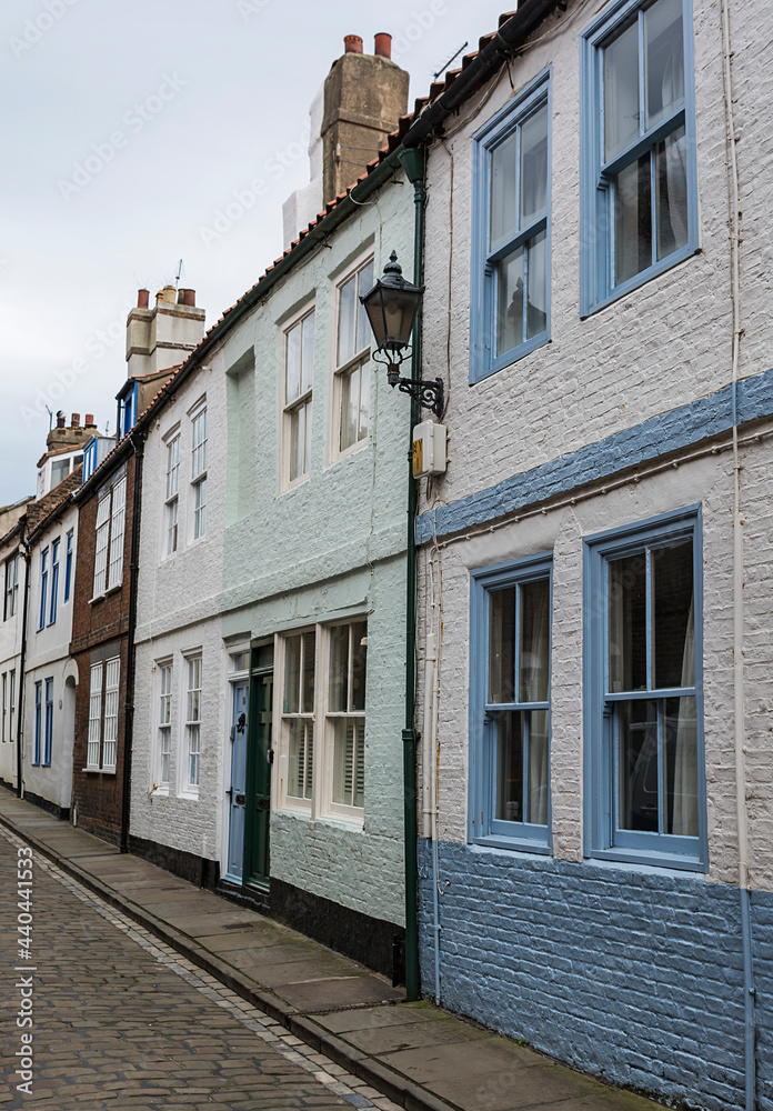 Generic traditional english village street with pastel painted houses.