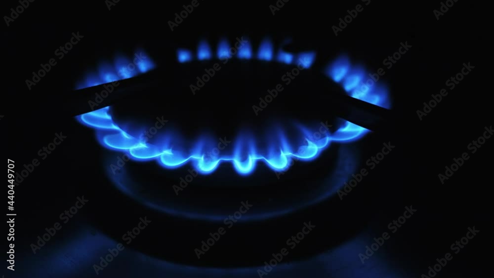 Moving flames of gas in gas cooker. Blue fire on stove in dark. Moving flames of gas in gas cooker. Blue fire on stove in dark.