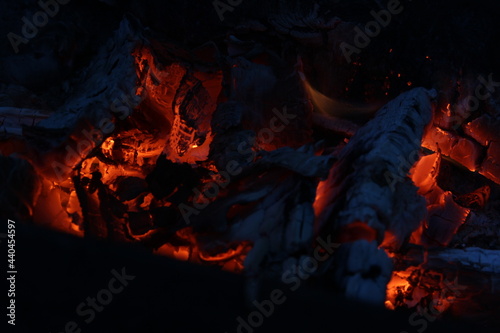 Smoldered logs burned in vivid fire close up. Atmospheric background with flame.