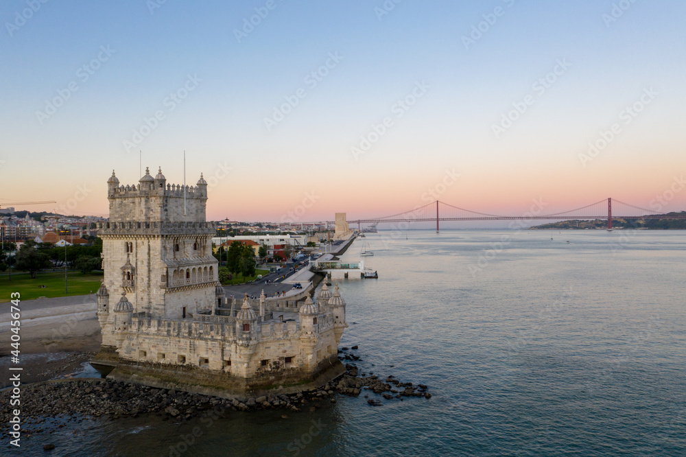 Aerial view of belem tower Lisbon in Portugal over the tagus river at the sunset and the 25 de april bridge on the background
