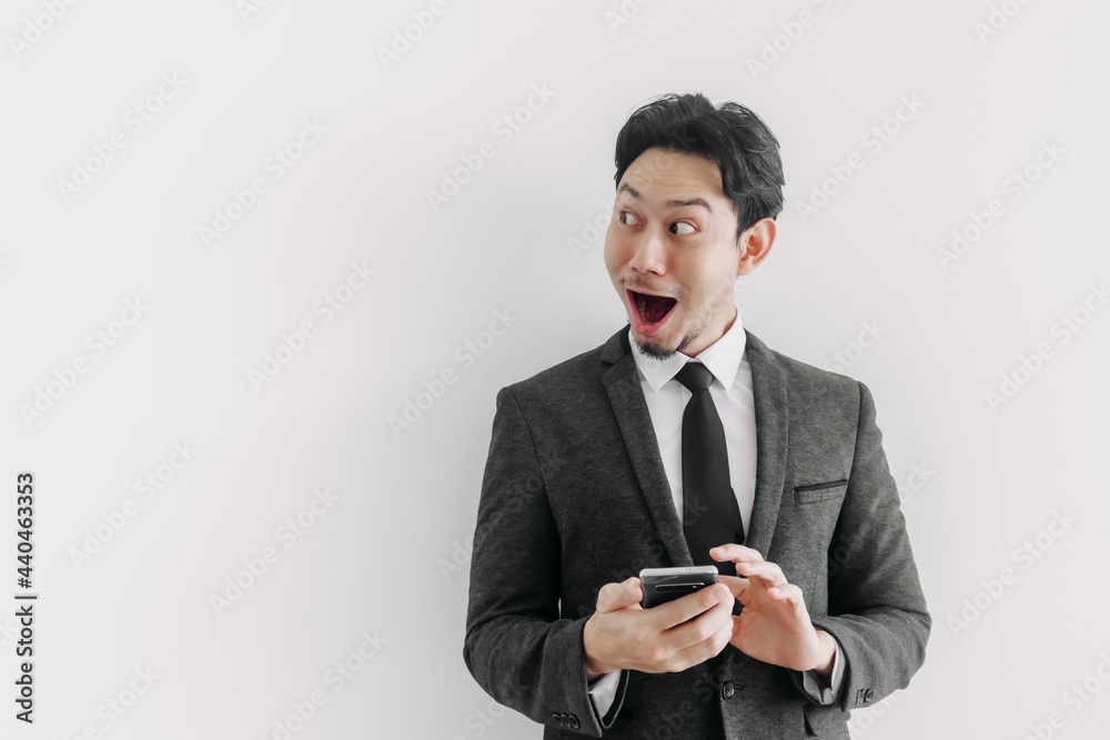 Wow and surprised face of Asian businessman use trade application on the phone. Wow and surprised face of Asian businessman use trade application on the phone.