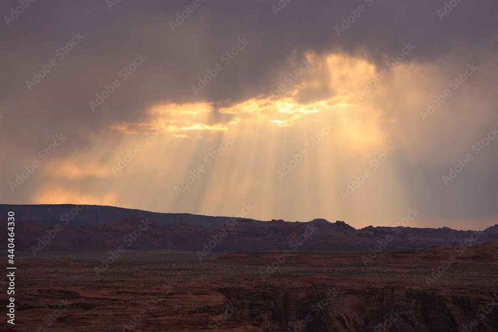 Rays of Sun Shining Through Clouds on the Horizon Behind Horseshoe Bend Near Page, Arizona