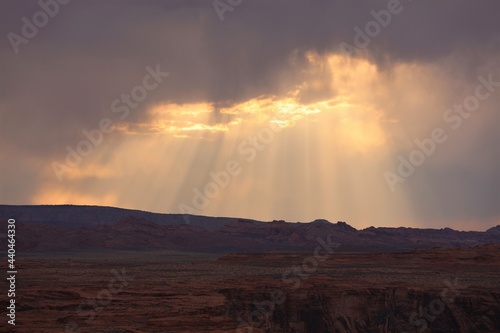 Rays of Sun Shining Through Clouds on the Horizon Behind Horseshoe Bend Near Page  Arizona