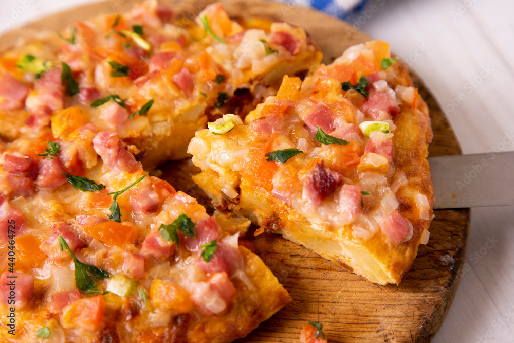 Spanish omelette with potatoes, zucchini and ham on top. Traditional tapa from southern Spain. Spanish omelette with potatoes, zucchini and ham on top. Traditional tapa from southern Spain.