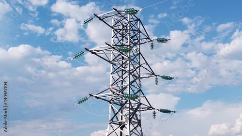High voltage power line support. Metal tower against a blue sky. Wires fit to the support. The video was taken from a drone.