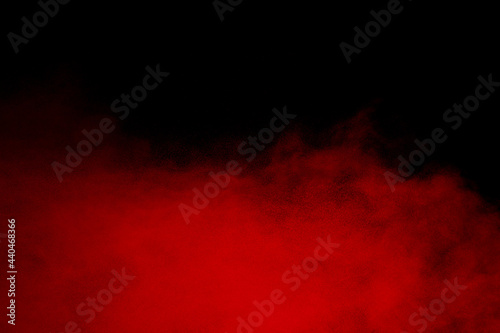Red powder explosion cloud on black background.