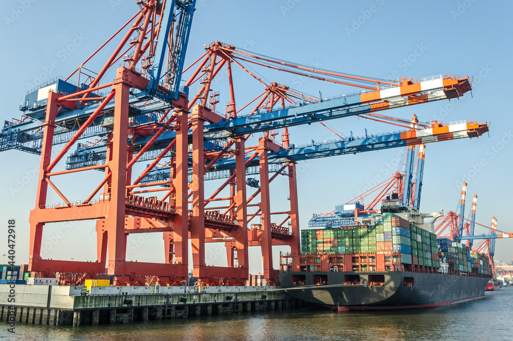 Large container vessel and harbour facilities at a container terminal in Hamburg, Germany