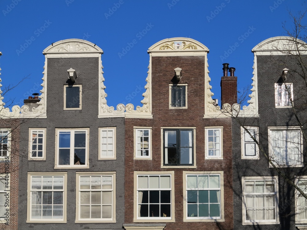 Amsterdam Historic Canal House Facades with Neck Gables Close Up Against a Blue Sky