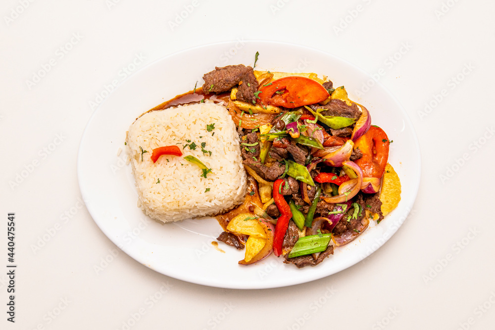 Tray of sauteed beef tenderloin cooked with Peruvian recipe with white rice, french fries and sauteed vegetables with soy sauce Tray of sauteed beef tenderloin cooked with Peruvian recipe with white rice, french fries and sauteed vegetables with soy sauce