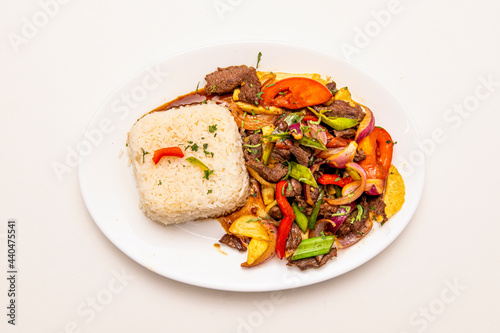Tray of sauteed beef tenderloin cooked with Peruvian recipe with white rice, french fries and sauteed vegetables with soy sauce